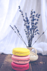 French macaroons and lavender on wooden table. Vintage toned food still life.
