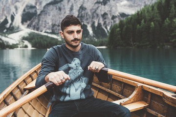 Man rowing a wood boat at Braies lake - 121570262
