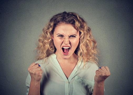 angry woman having nervous breakdown screaming fists up in air