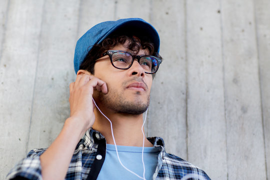 man with earphones listening to music on street