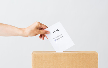 man putting his vote into ballot box on election