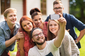 friends taking selfie by smartphone at summer