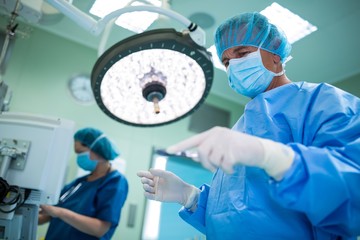 Surgeon holding surgical tool in operation room