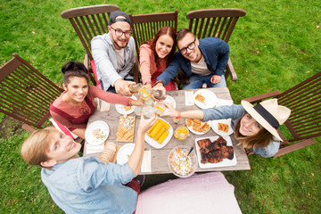 happy friends having dinner at summer garden party