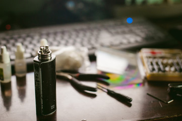 man prepares coil electronic cigarette smoking tasty vape juice. Device for the vaporization...
