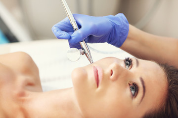 Woman having facial treatment in beauty salon - obrazy, fototapety, plakaty