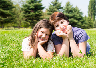 Fototapeta premium Happy mom and child girl hugging. The concept of childhood and family. Beautiful Mother and her baby outdoor