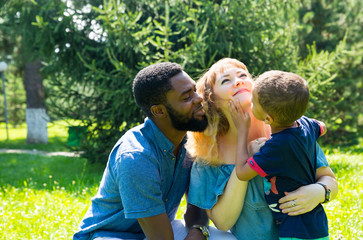 African American happy family: black father, mom and baby boy on nature. Use it for a child, parenting or love concept