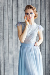 Fototapeta premium Beautiful young girl in a blue dress