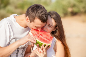 smiling young couple eating fresh melon together