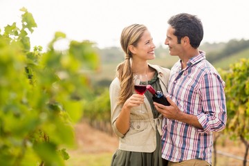 Happy couple holding glass and a bottle of wine