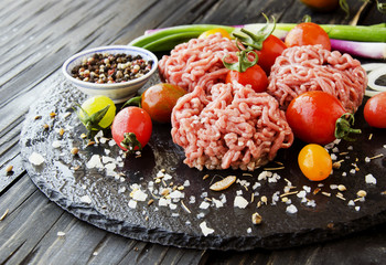 raw minced meat, vegetables with salt and spices, selective focus