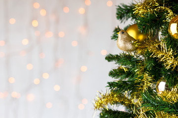 Fototapeta na wymiar Gold glitter robin on Christmas tree. Copy space.