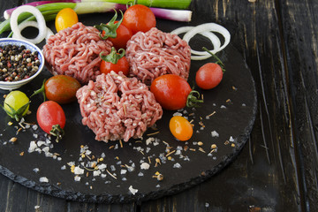 raw minced meat, vegetables with salt and spices, selective focus