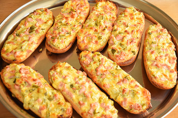 An open faced sandwich with bacon and cheese