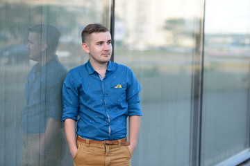 Blonde attractive man sitting in front of an office building