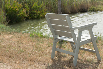 Wooden chair on lake for relaxing at sunset