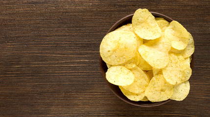 Potato chips in bowl on a table, top view. - 121580032