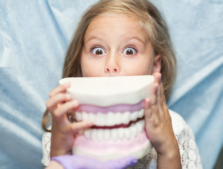 Dentist curing a child patient in the dental office in a pleasant environment. There are specialized equipment to treat all types of dental diseases in the office.