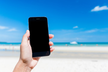Beautiful woman's hand using smart phone at beach. Smartphone black screen. Girl using black color smartphone at Beach from Thailand.