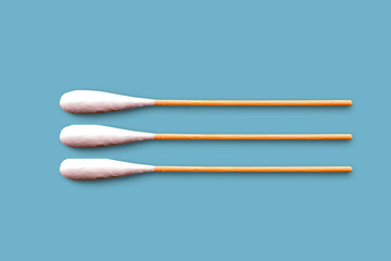 Three cotton brushes on blue background