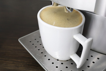 coffee in a white cup on the background of coffee machine