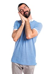Fototapeta premium Man with blue shirt doing sleep gesture