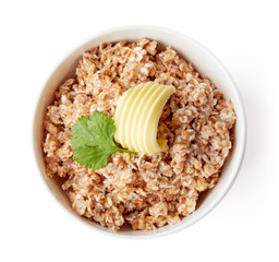 Bowl of rye flake porridge isolated on white, from above