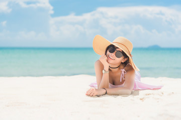 Asian girl at the beach. Girls wearing glasses lying on the beach. Woman at sea from Thailand. Vivid tone.

