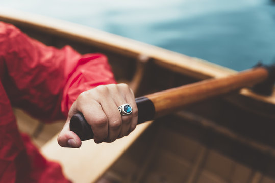  Close up of hand with ruby ring rowing a wood boat in the lake