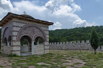 Fototapeta premium Stone slate-roof of old medieval alcove with cross in restored Montenegrin or Giginski monastery St. St. Cosmas and Damian, mountain Kitka, Breznik, Pernik region, Bulgaria 