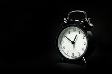 black retro alarm clock in dark background.