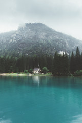 Church close to Braies lake, trees and mountains - 121589867