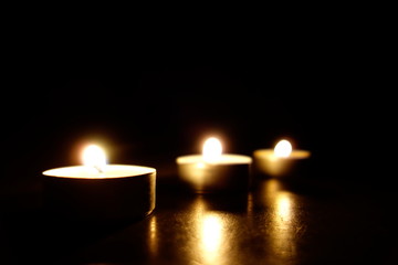 Candles burning. Dark background.