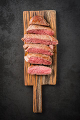 Sous vide cooked and seared fillet steak on rustic wooden board