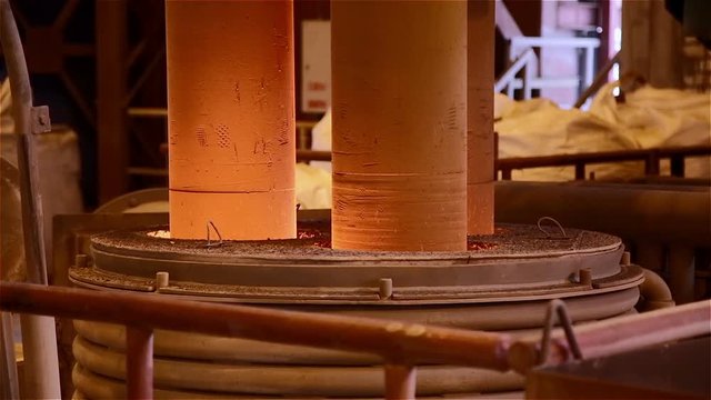 Steel Plant. Lowered Graphite Electrodes Melting Metal. Closeup