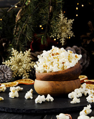 Obraz na płótnie Canvas popcorn in a wooden plate on the background of Christmas