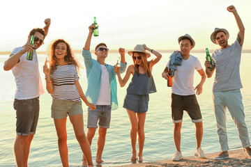 Group of friends hanging out with beer at the beach