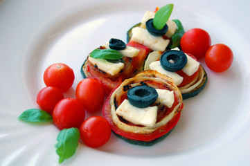 Grilled zucchini slices with tomatoes, black olives, goat cheese and basil