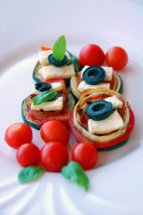 Grilled zucchini slices with tomatoes, black olives, goat cheese and basil