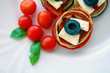 Grilled zucchini slices with tomatoes, black olives, goat cheese and basil