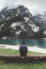 Man sitting on tree looking Braies lake and mountains - 121596416