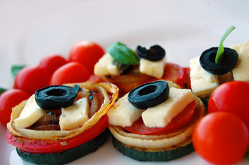 Grilled zucchini slices with tomatoes, black olives, goat cheese and basil