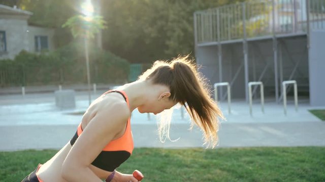 Young girl doing exercises with weights outdoor in 4K