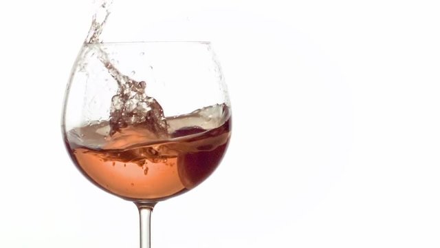 grain de raisin qui tombe dans un verre de vin ros&eacute; en slow motion 500 fps