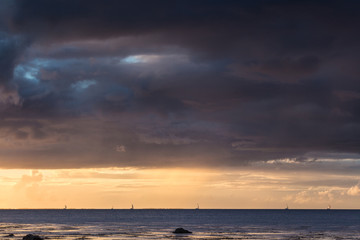 Sailing under dark skies along the Wild Atlantic Way in Tralee Bay, County Kerry, Ireland