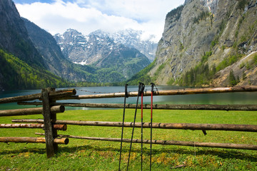 Nordic walking sticks on the fence with  Obersee and Watzmann peak in the background, Berchtesgaden Alps, Germany