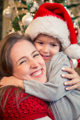 Joyful mother and son embracing at Christmas morning.