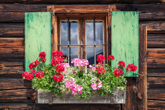 Fototapeta Window of an old wooden cabin in the alps
