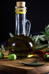 Olive oil in a bottle, vertical, front view, dark photo
